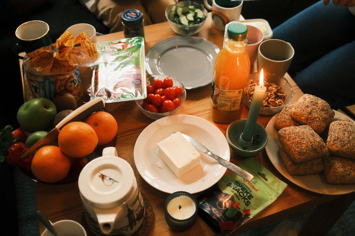 A cozy breakfast spread featuring fresh fruits, bread, and juice, surrounded by warm candlelight.