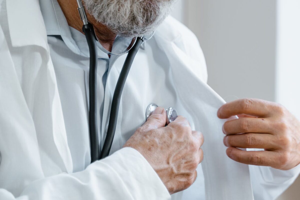 service-02 Close-up of a doctor adjusting a stethoscope while in a medical consultation.